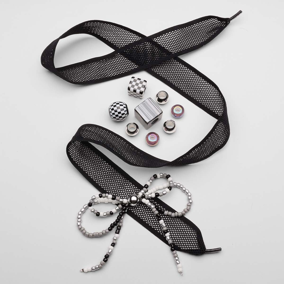 Black-mesh-laces-with-checkered-charms-and-beaded-bow-accessory