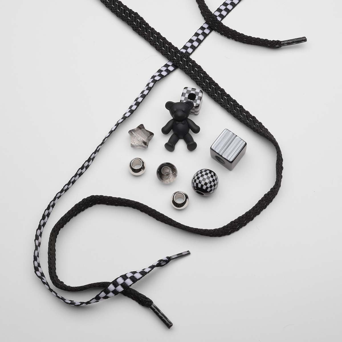 Black-and-white-checkered-laces-with-charms-including-bear-star-and-checkered-ball
